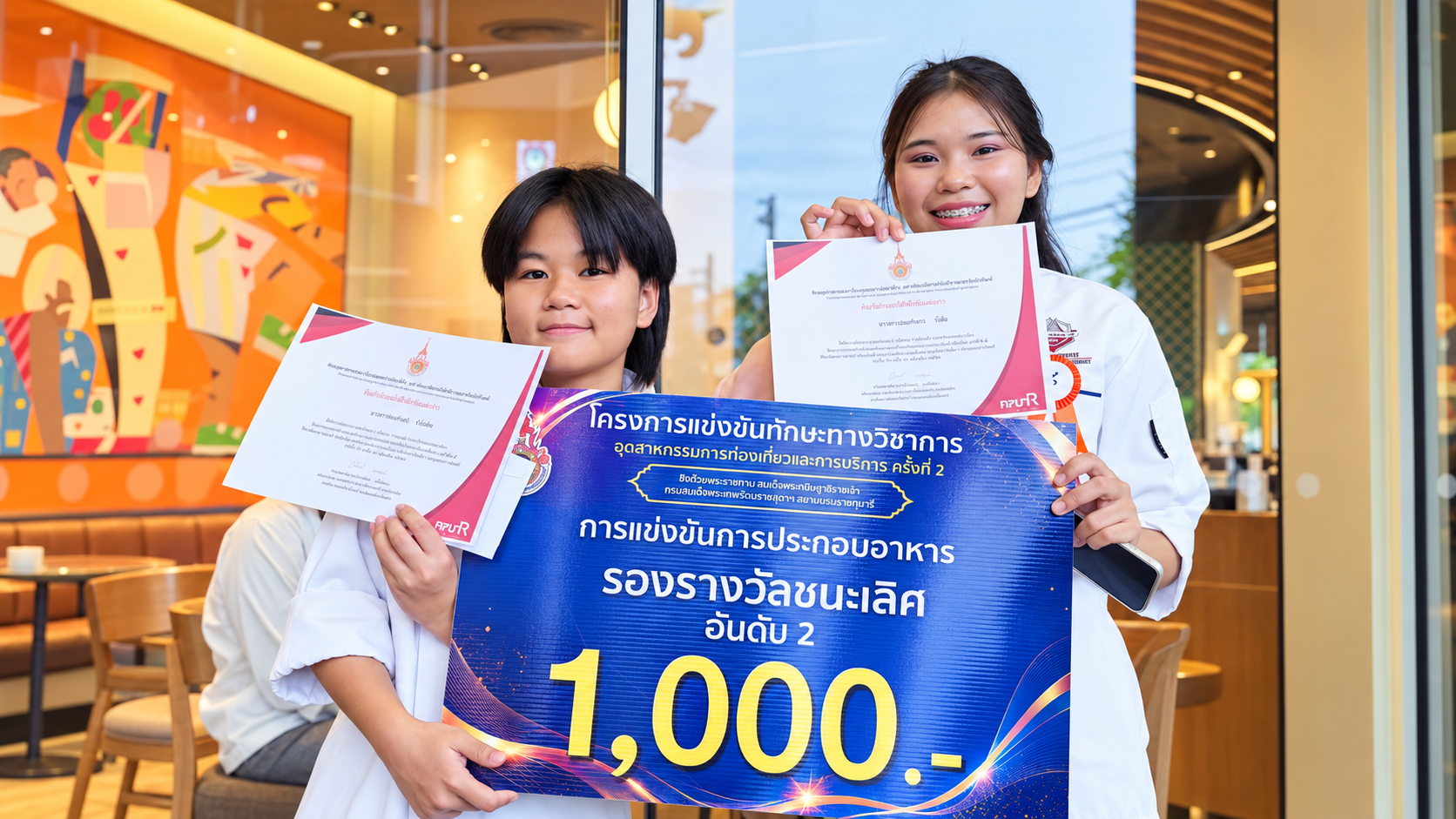 นักศึกษาสาขาอาหารสร้างสรรค์ถือประกาศนียบัตรจากการแข่งขันทักษะด้านอาหาร